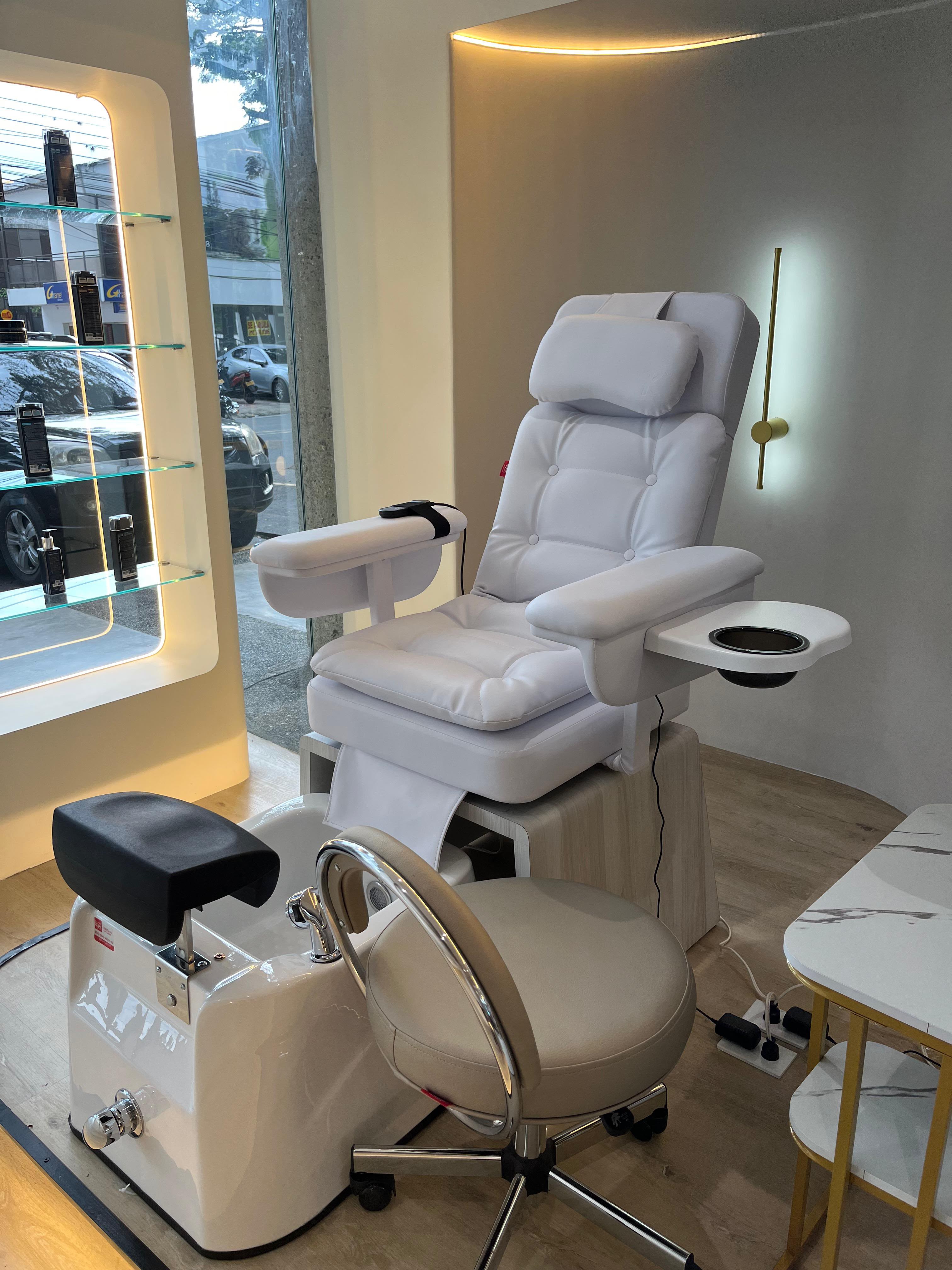 Silla de pedicure blanca con vitrina de productos premium en Coco Cali